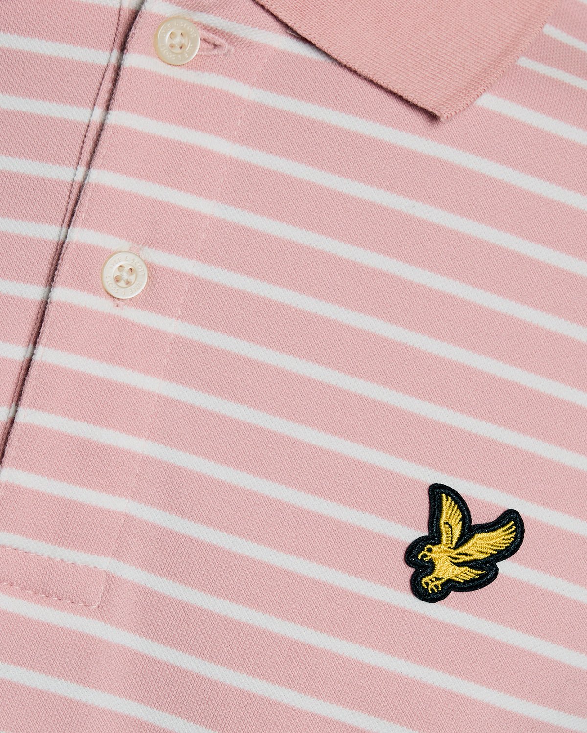 Homme portant un polo breton en piqué rose pamplemousse et blanc