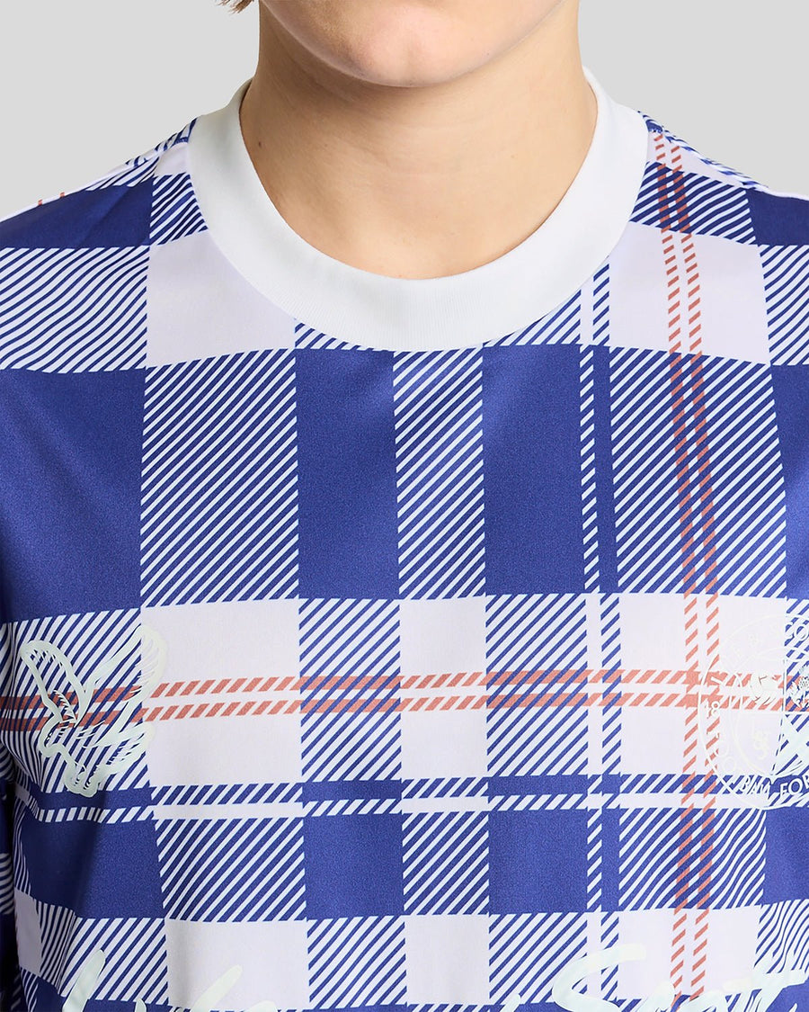 Homme portant un maillot de football à carreaux tartan de style sportif, couleur Now Blue