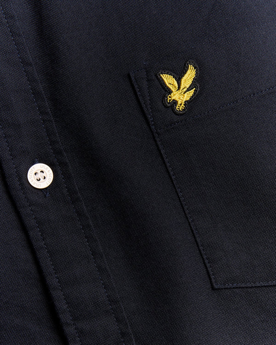 Un homme porte une chemise Oxford en coton à boutons, bleu marine foncé