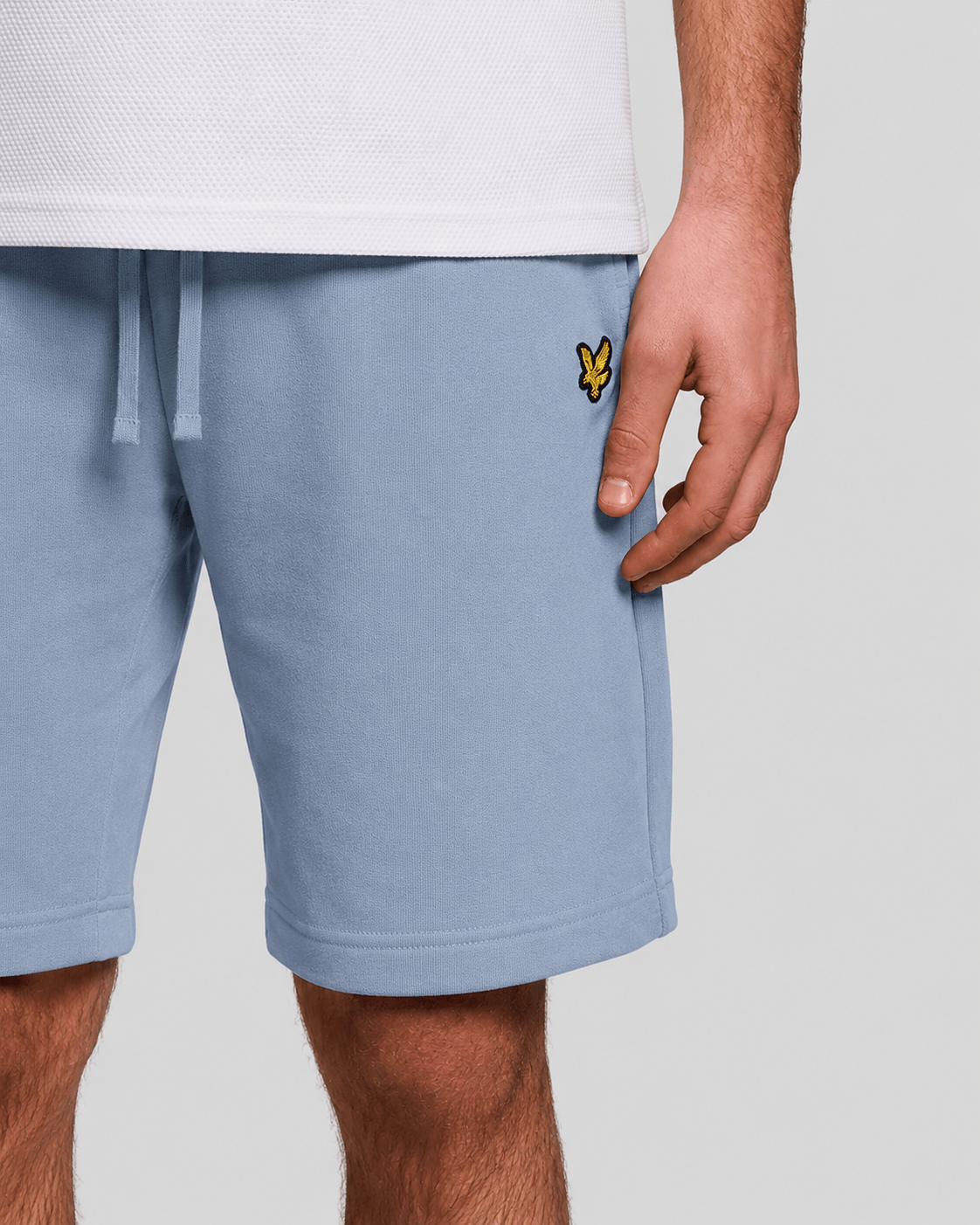 Un homme porte un short de sport en coton bleu opale