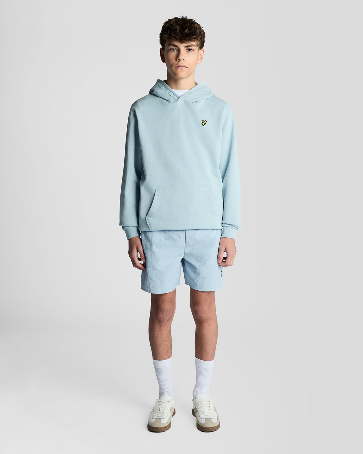Un homme porte un sweat à capuche en coton Loopback bleu opale