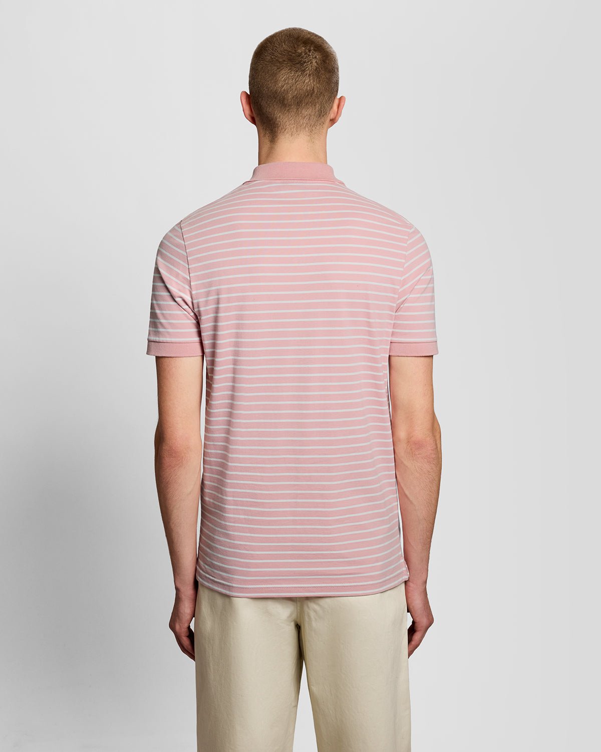 Homme portant un polo breton en piqué rose pamplemousse et blanc