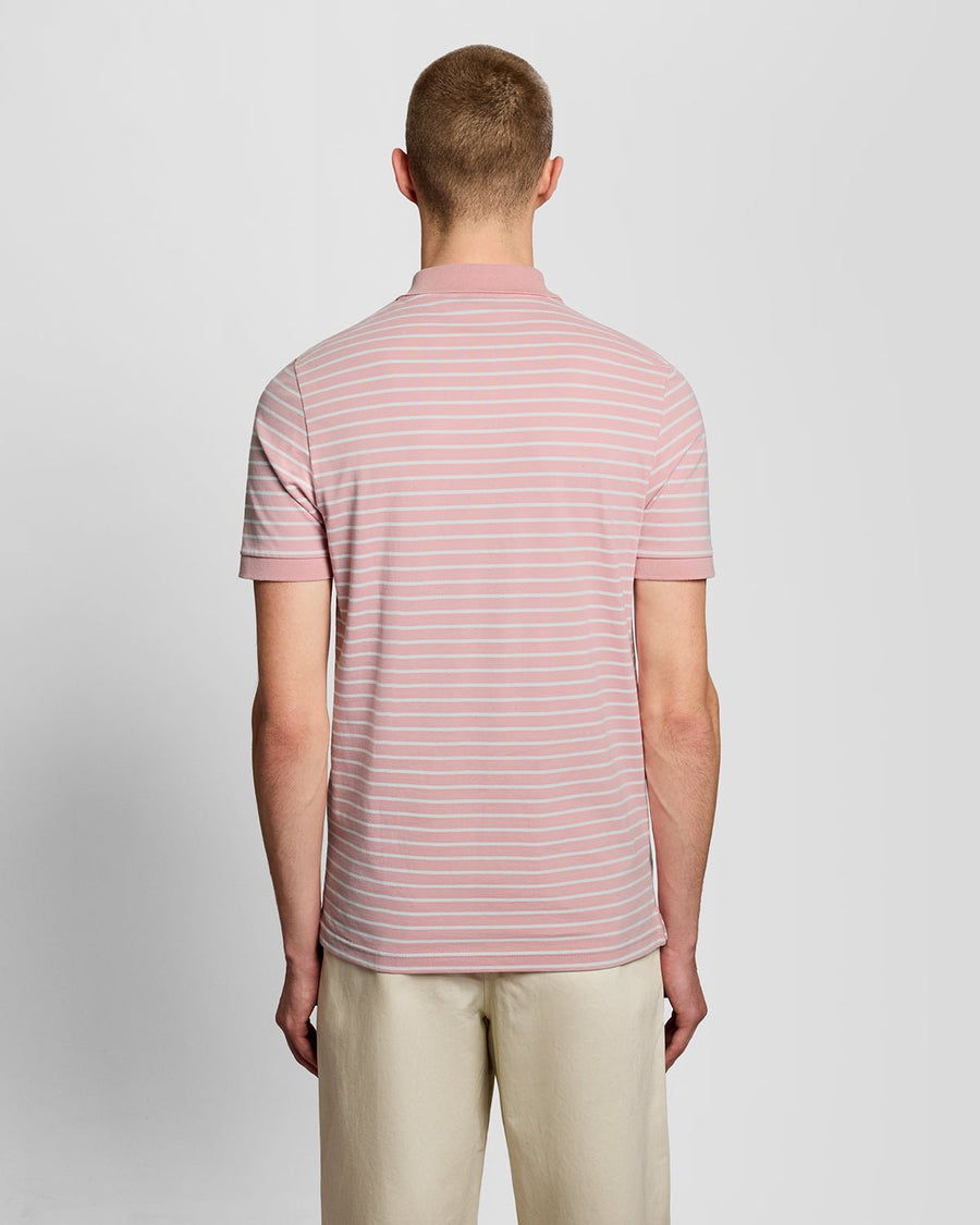 Homme portant un polo breton en piqué rose pamplemousse et blanc