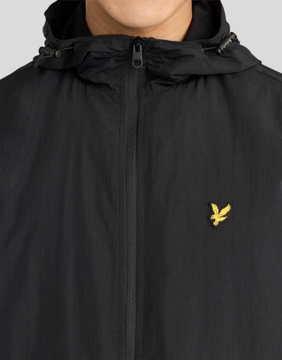 Hombre con chaqueta con capucha impermeable y costuras selladas en negro azabache