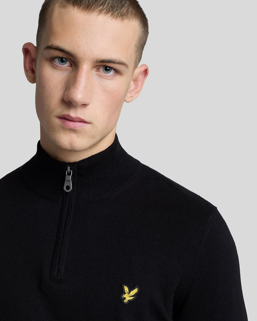 Man wears Cotton Merino 1/4 Zip Jumper in Jet Black