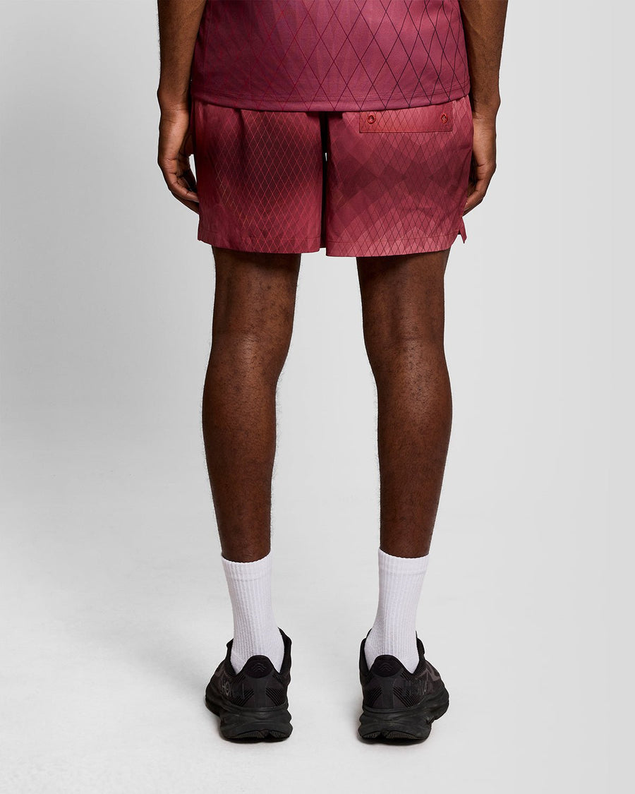 Un homme porte un short de bain Monogram Geometric couleur figue