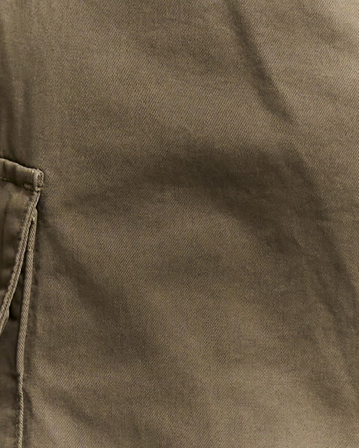 Un homme porte un pantalon cargo à revers de couleur kaki cendré