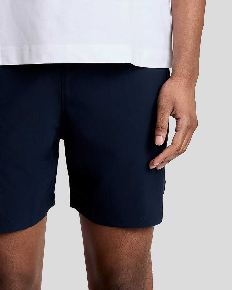 Un homme porte un short de bain bleu marine foncé