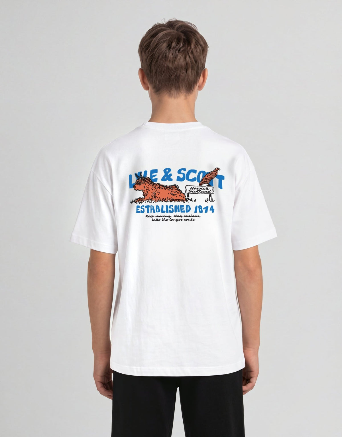 Jongen draagt een T-shirt met een afbeelding van een Highland-koe in het wit