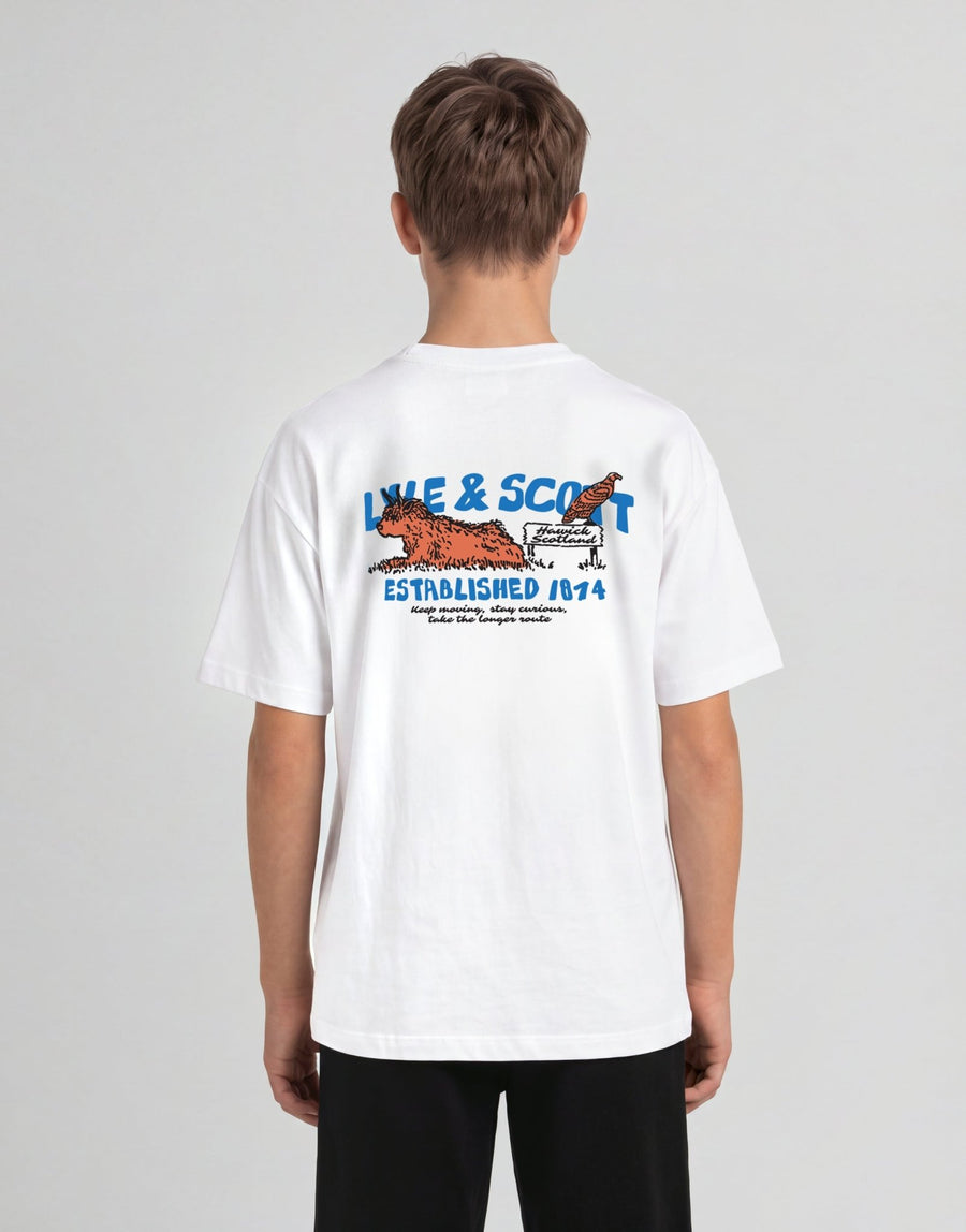 Jongen draagt een T-shirt met een afbeelding van een Highland-koe in het wit