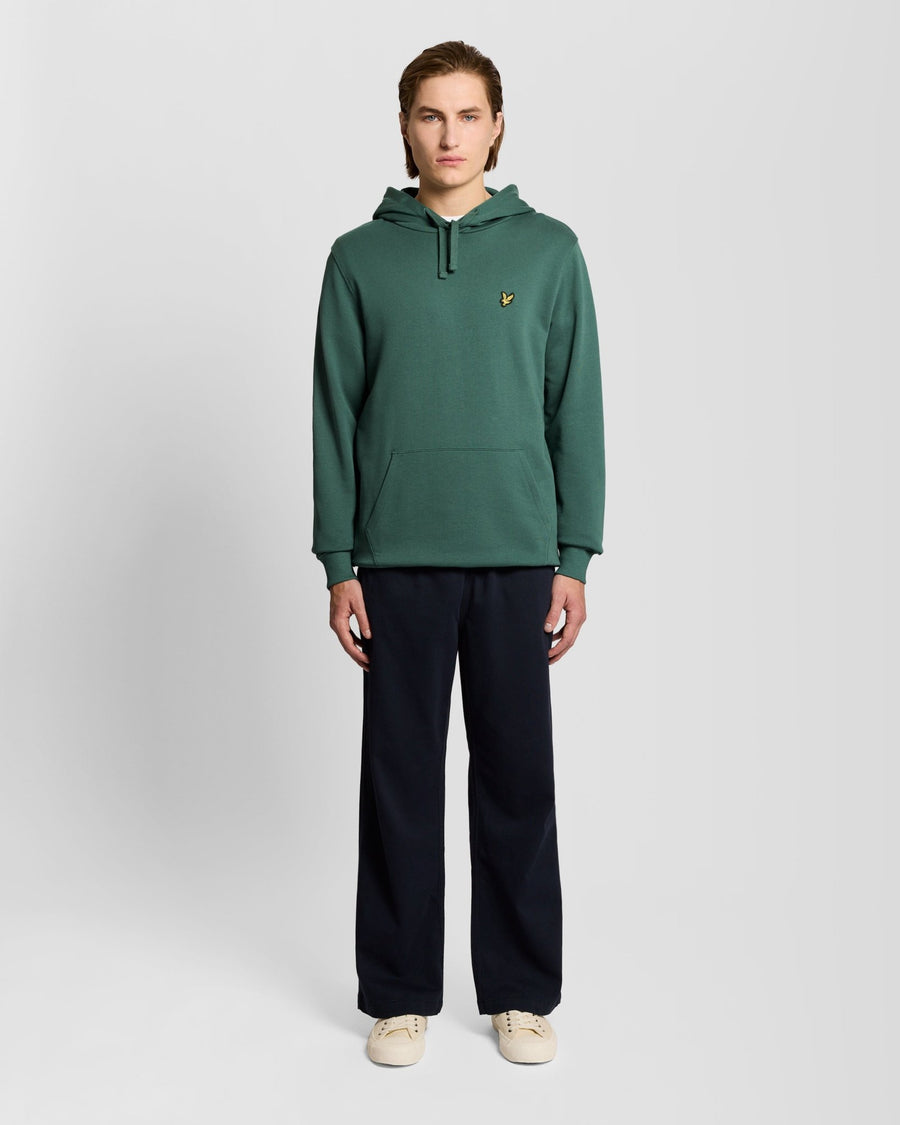 L'uomo indossa una felpa con cappuccio Loopback in cotone color Everglade