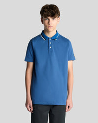 Man wears Tipped Logo Polo Shirt in Dark Cornflower