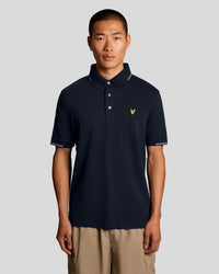 Man wears Fine Cotton Tipped Polo Shirt in Dark Navy/ Chalk Blue