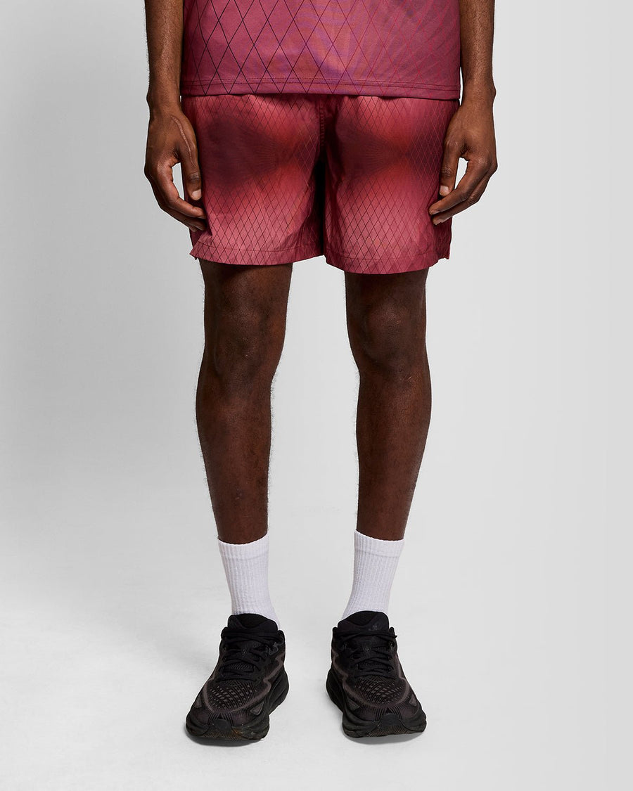 Un homme porte un short de bain Monogram Geometric couleur figue