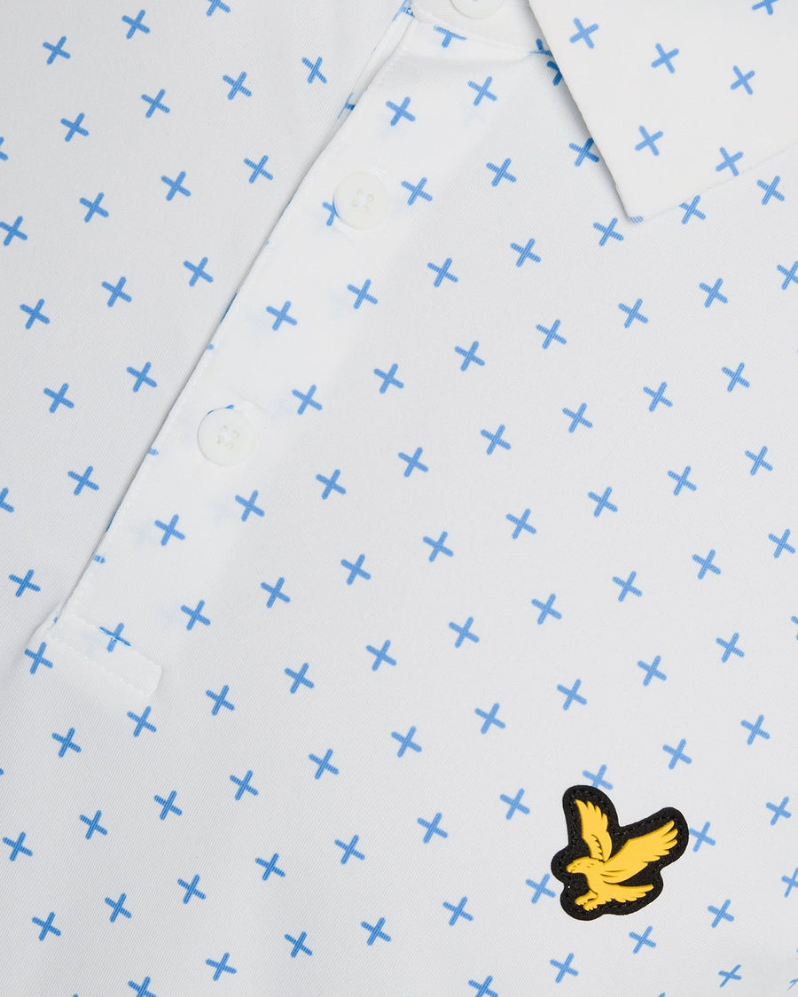 Un homme porte un polo blanc à motif croix