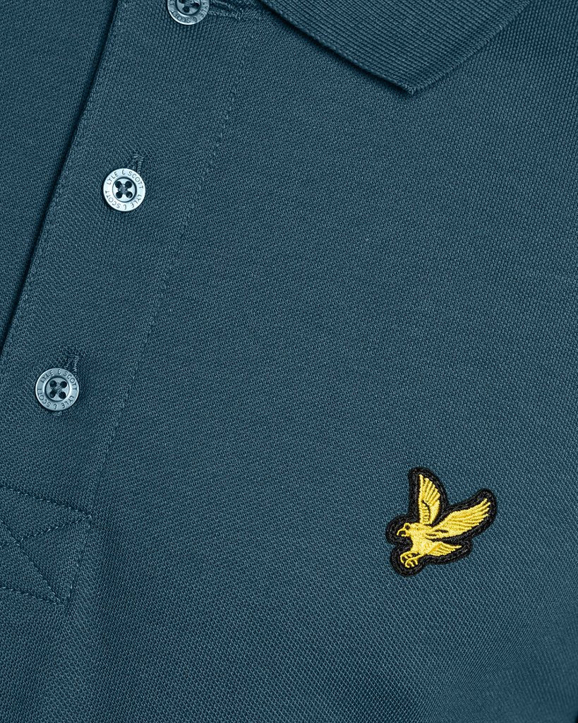 Un homme porte un polo « Everyday Cotton » de couleur bleu sarcelle intense