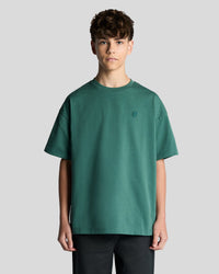 Man wears Heavy Weight Relaxed T-Shirt in Everglade
