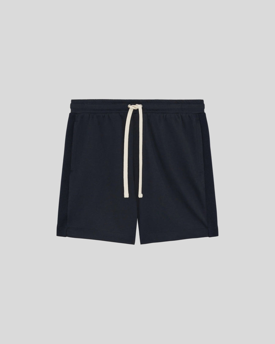 Un homme porte un short de survêtement Interlock bleu marine foncé