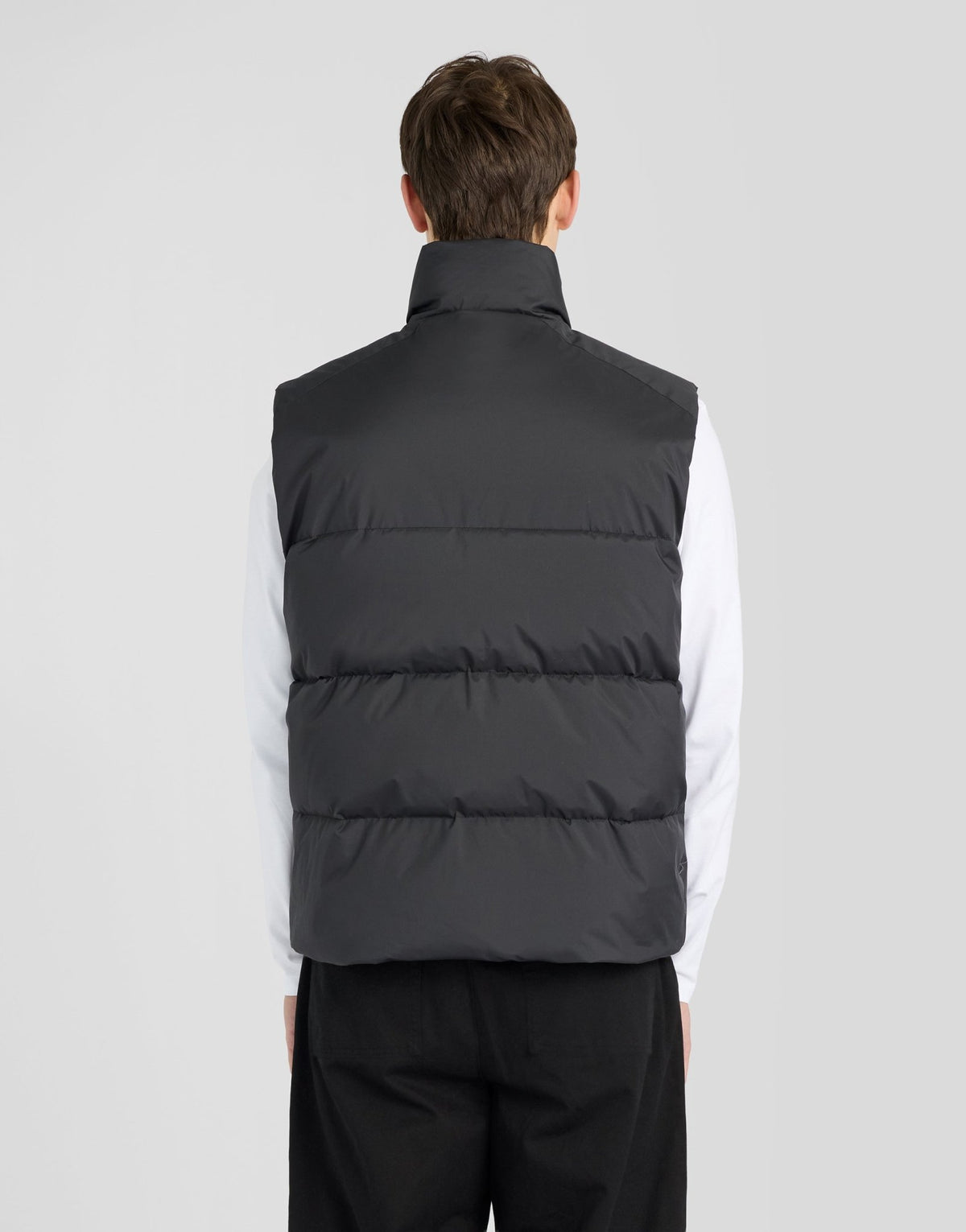 Man wears Funnel Neck Puffer Gilet in Jet Black
