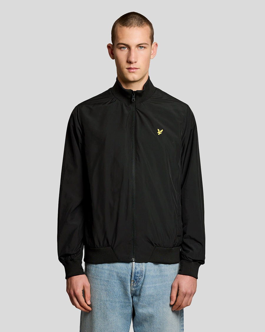 Un homme porte une veste à col cheminée de couleur noir jais