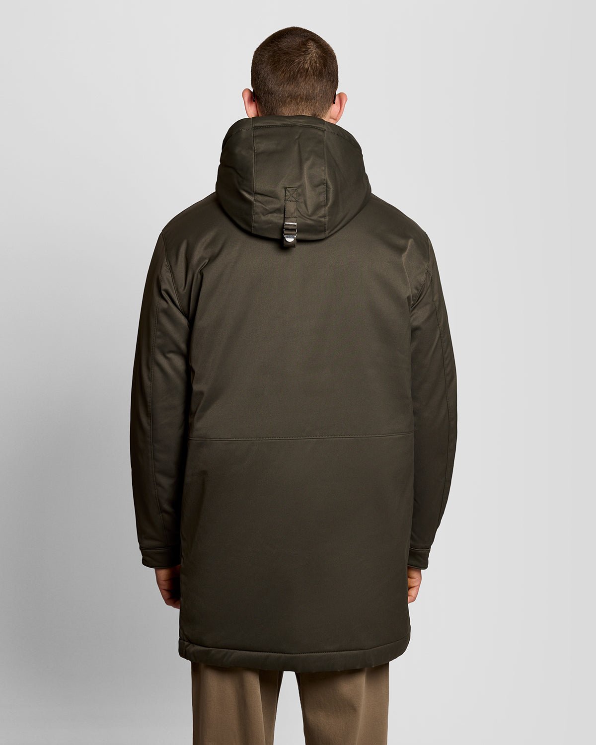 Un homme porte une parka matelassée de couleur olive