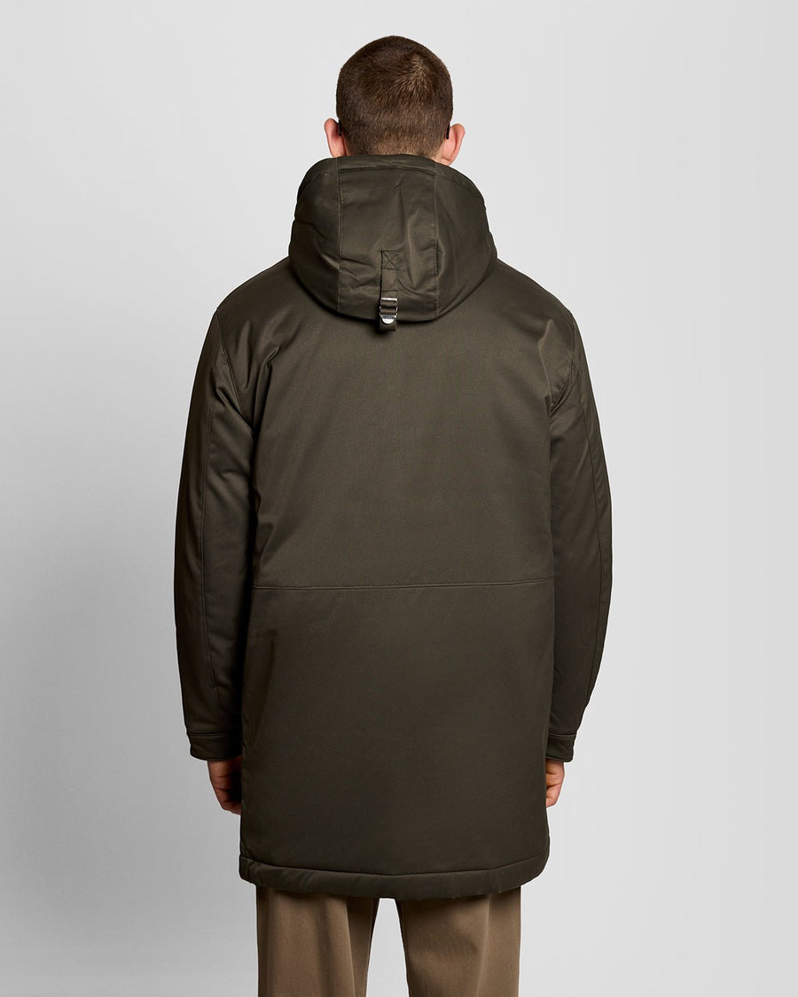 Un homme porte une parka matelassée de couleur olive