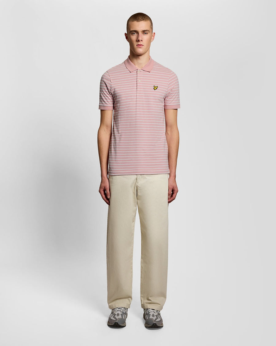 Homme portant un polo breton en piqué rose pamplemousse et blanc