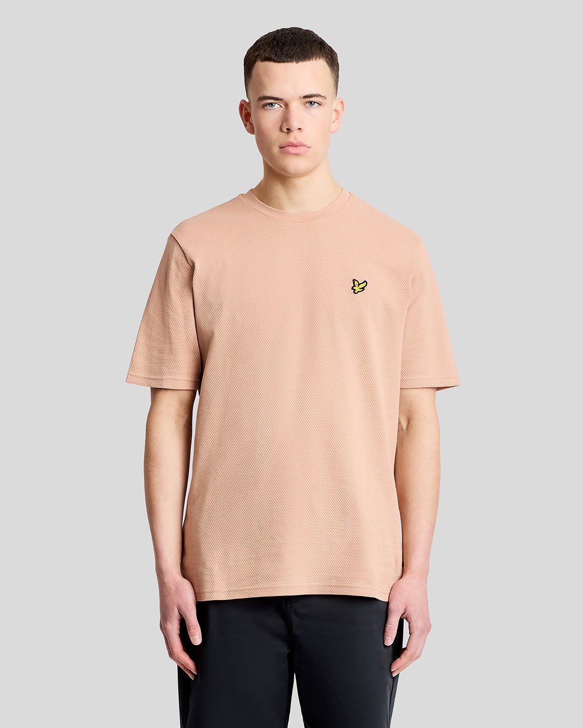 Un homme porte un t-shirt en jacquard texturé couleur orge