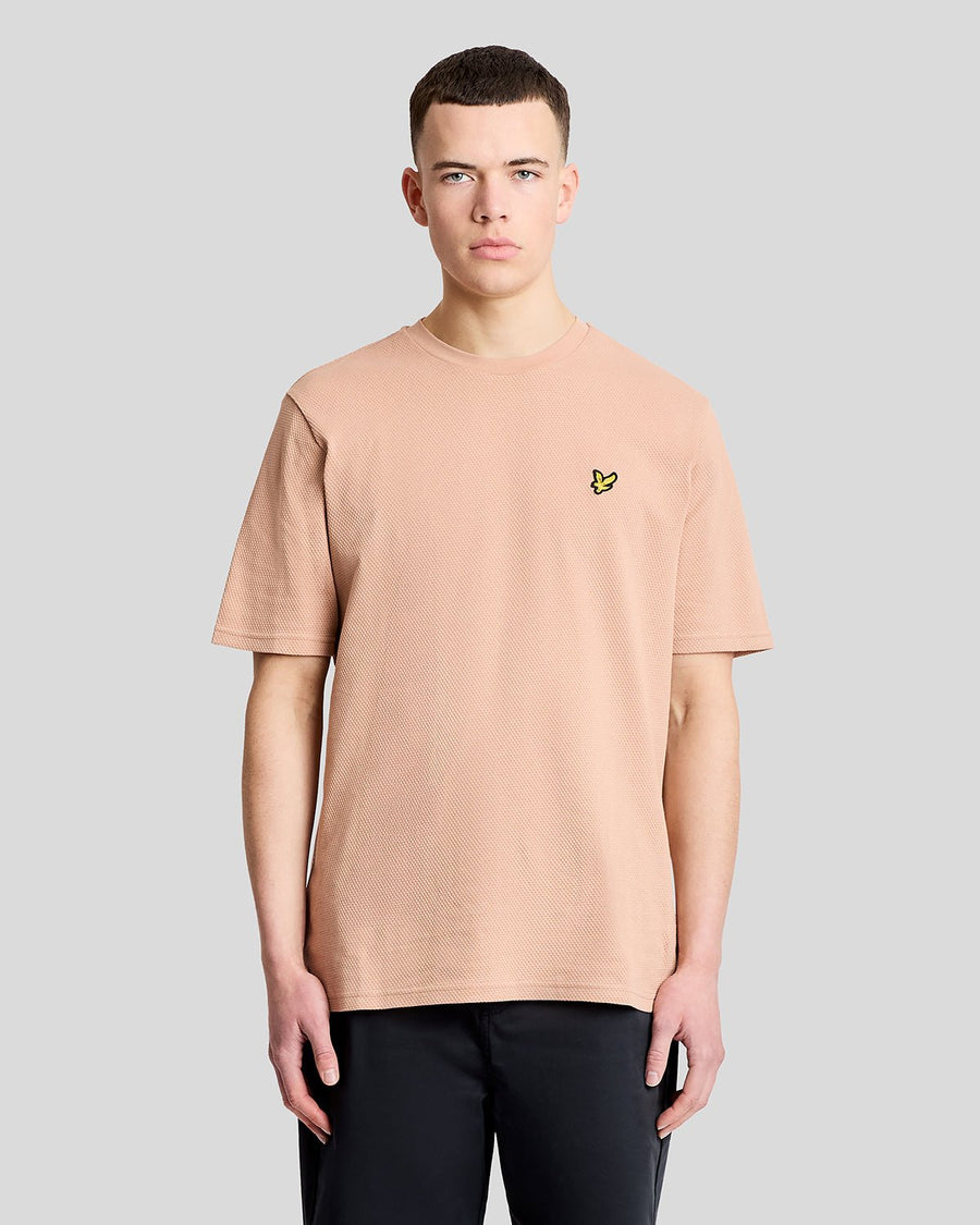 Un homme porte un t-shirt en jacquard texturé couleur orge