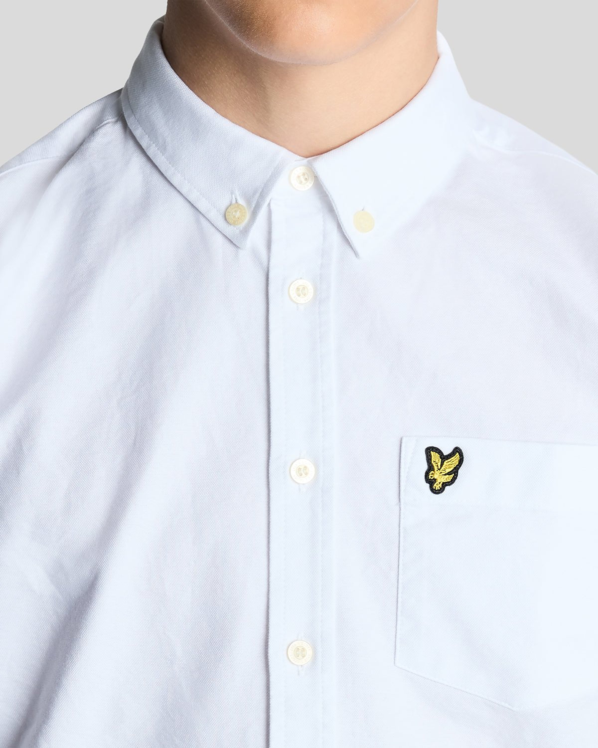 Un homme porte une chemise Oxford en coton à boutons, de couleur blanche