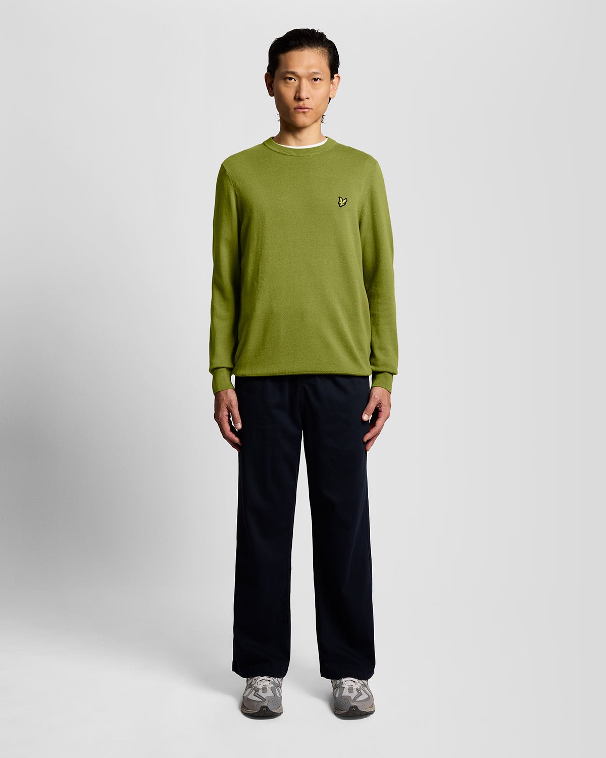 Homme portant un pull à col rond en coton vert buisson
