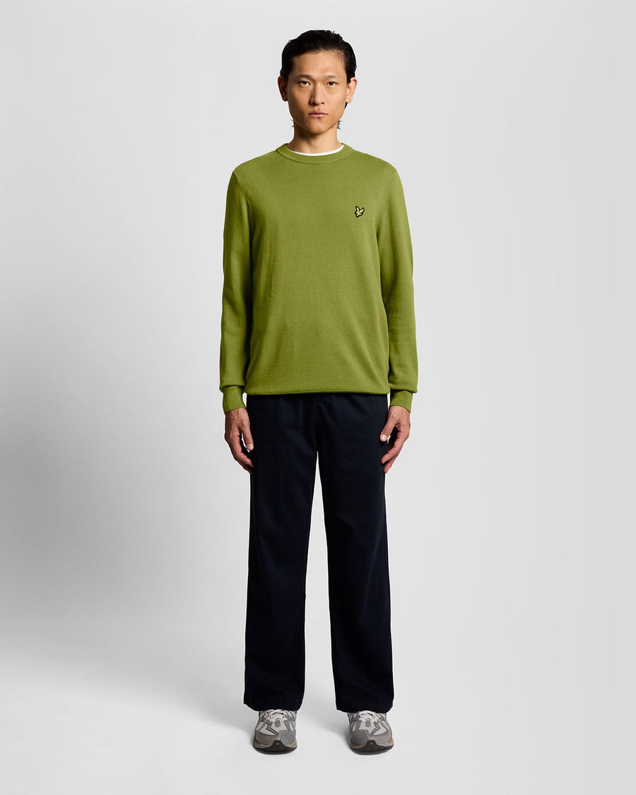 Homme portant un pull à col rond en coton vert buisson