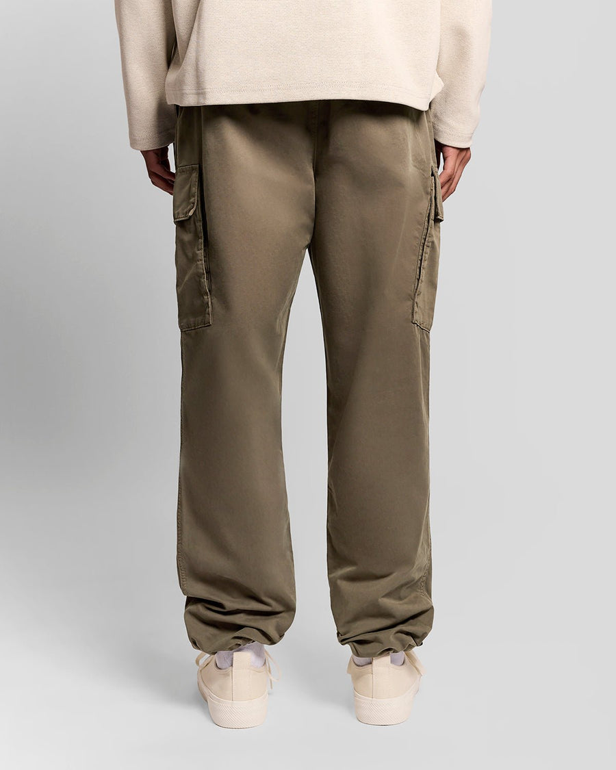 Un homme porte un pantalon cargo à revers de couleur kaki cendré