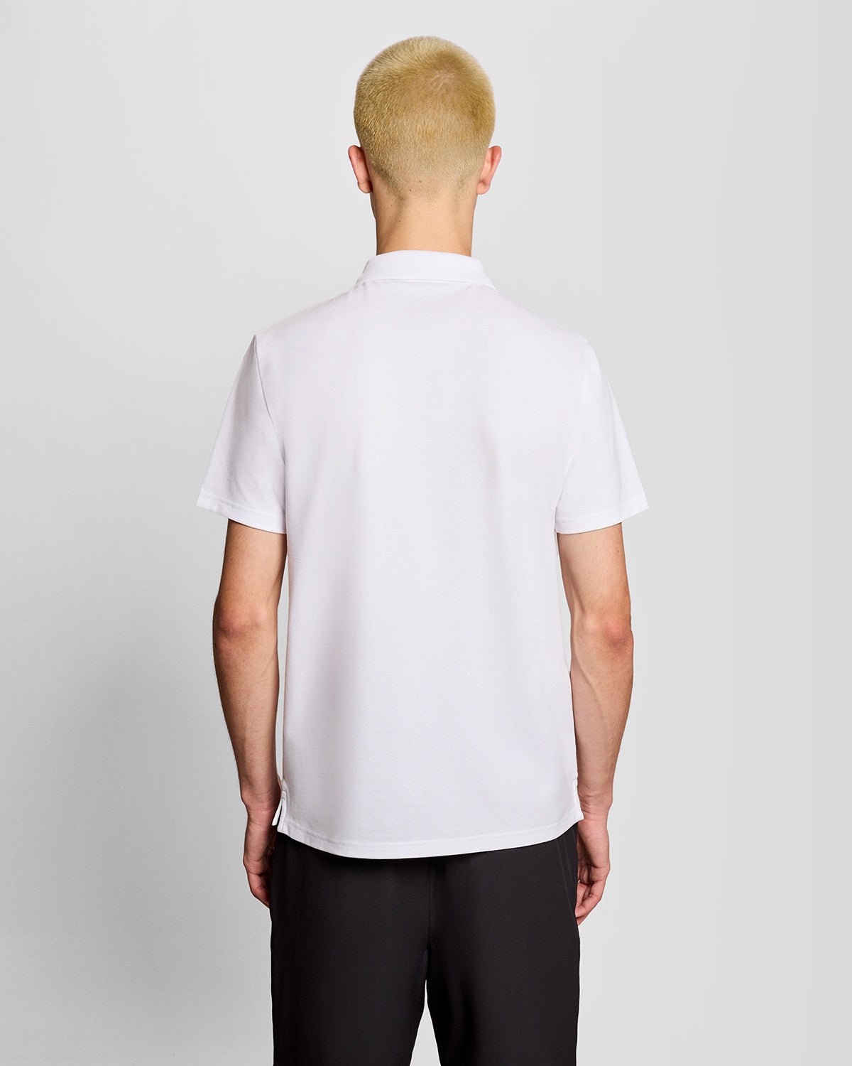 Un homme porte un polo de sport blanc