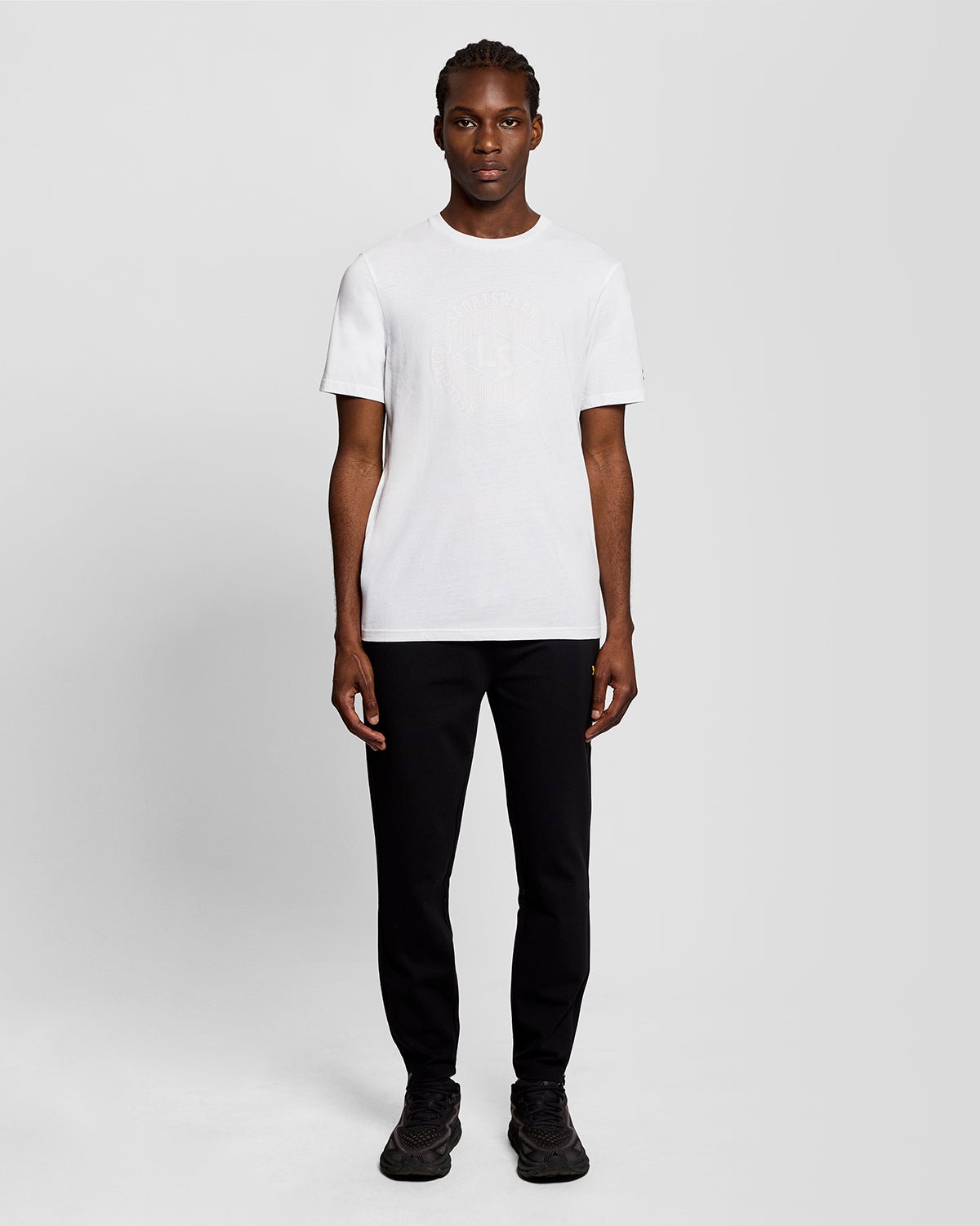 Homme portant un t-shirt blanc avec le logo graphique « Sports Redefined »