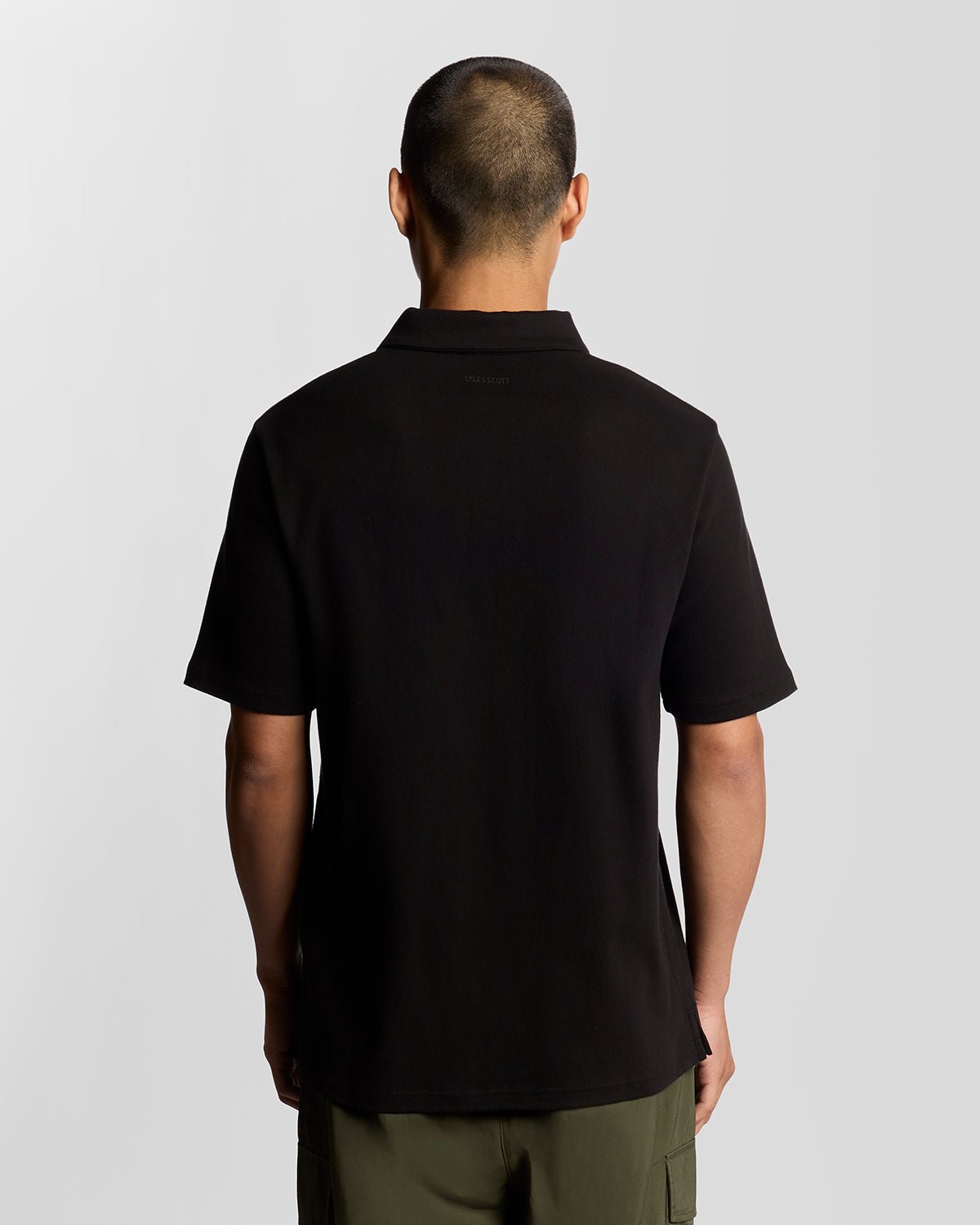 Man wears Interlock Zipped Polo Shirt in Jet Black