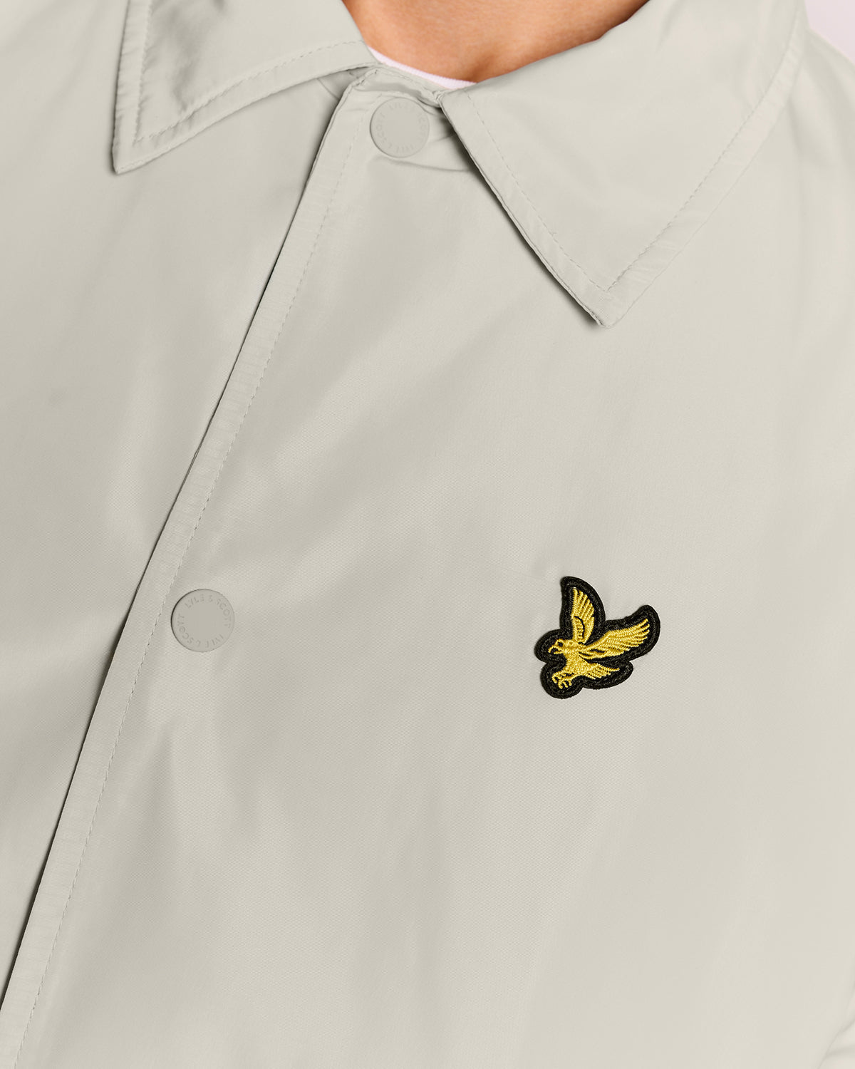 Un homme porte une veste Coach légère de couleur Cove