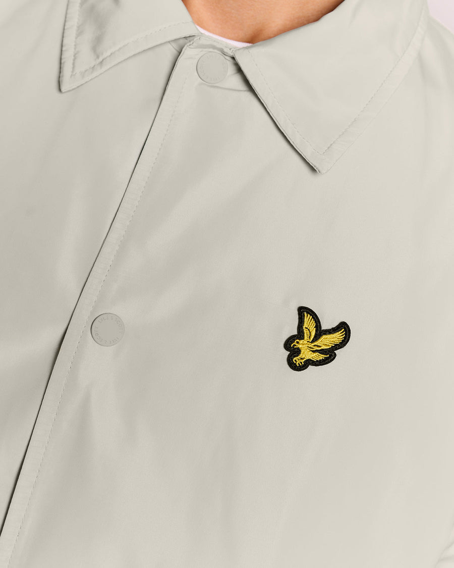Un homme porte une veste Coach légère de couleur Cove