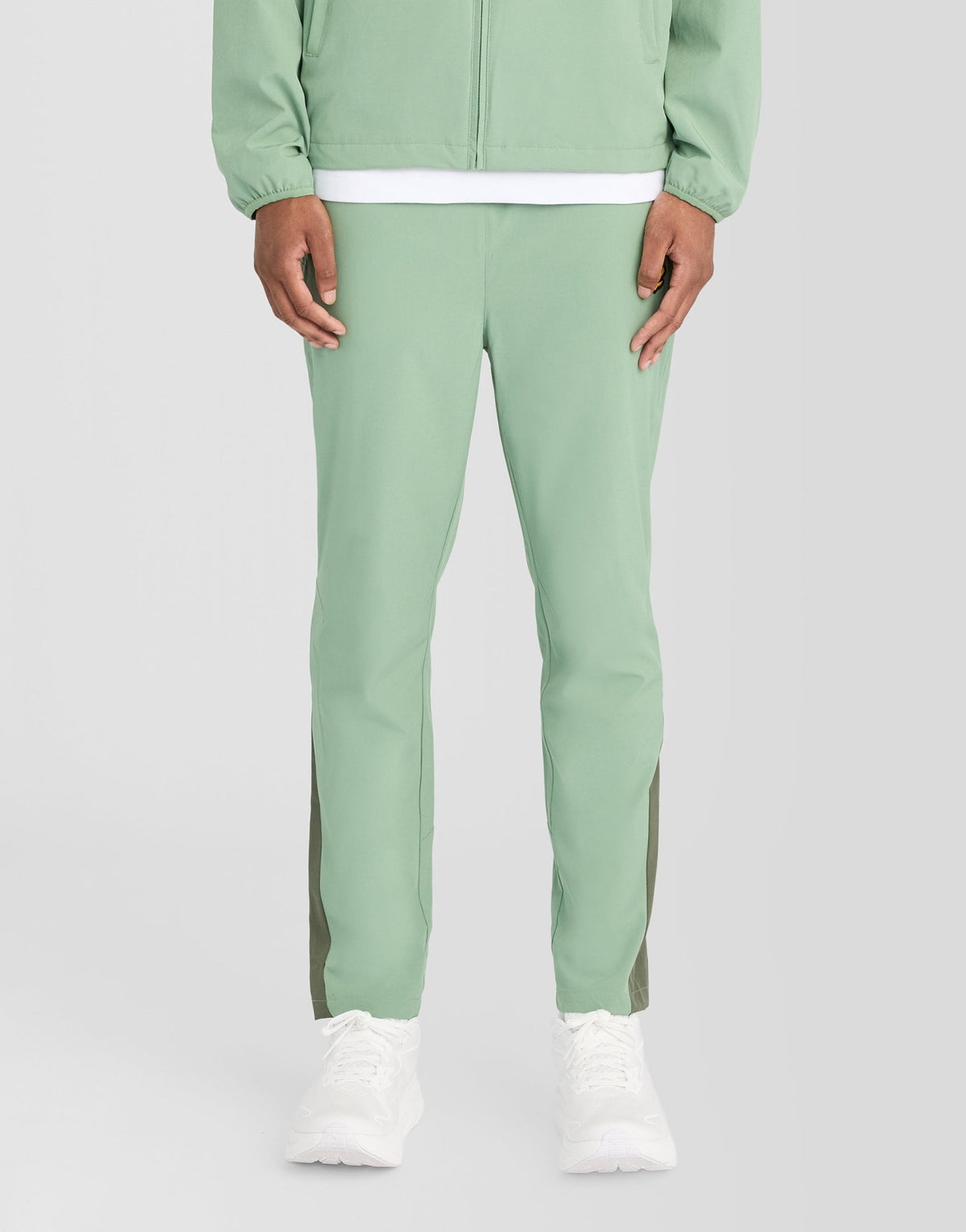 Man bär träningsbyxor med paneler i färgerna Botanical Green/Cactus Green