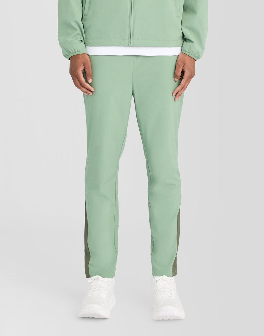 Man bär träningsbyxor med paneler i färgerna Botanical Green/Cactus Green