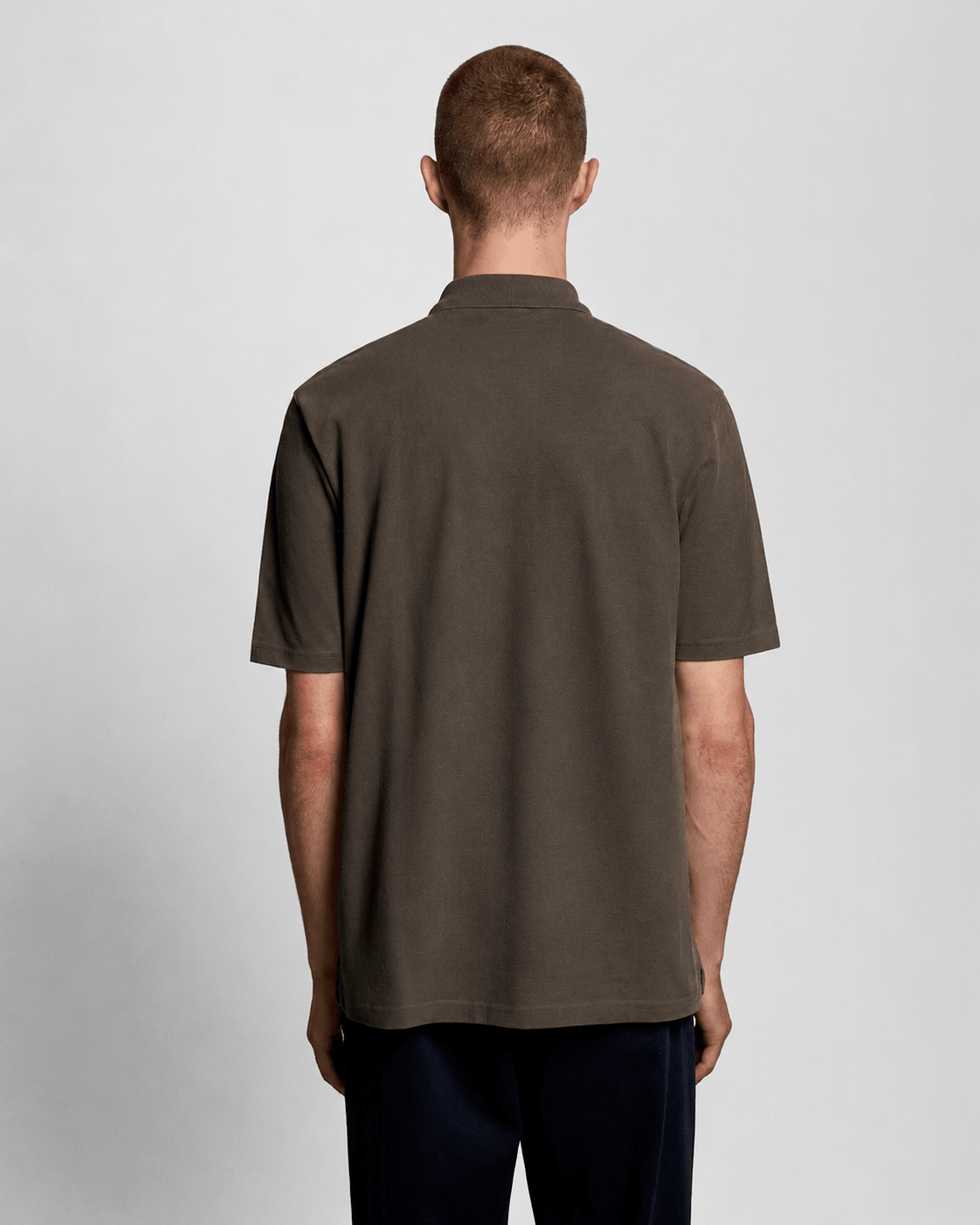 Homme portant un polo en coton épais, noir mat