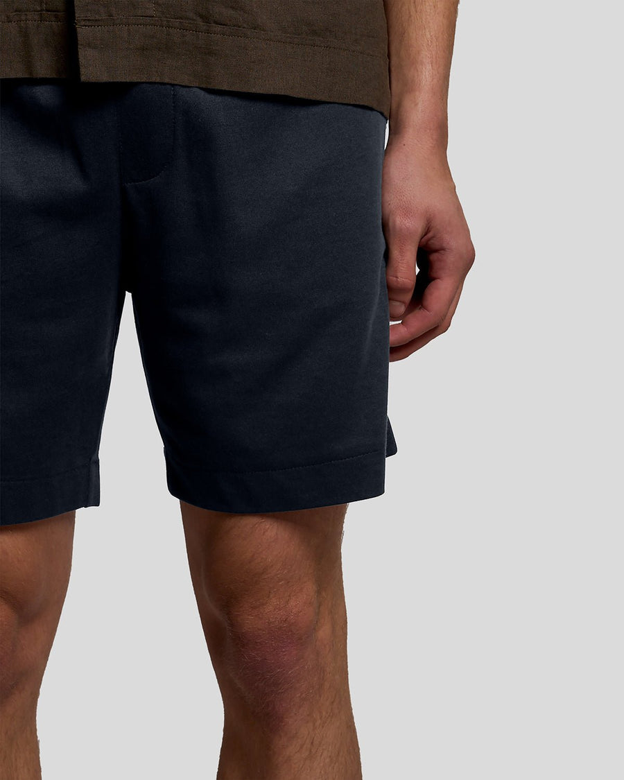 Un homme porte un short de survêtement Interlock bleu marine foncé