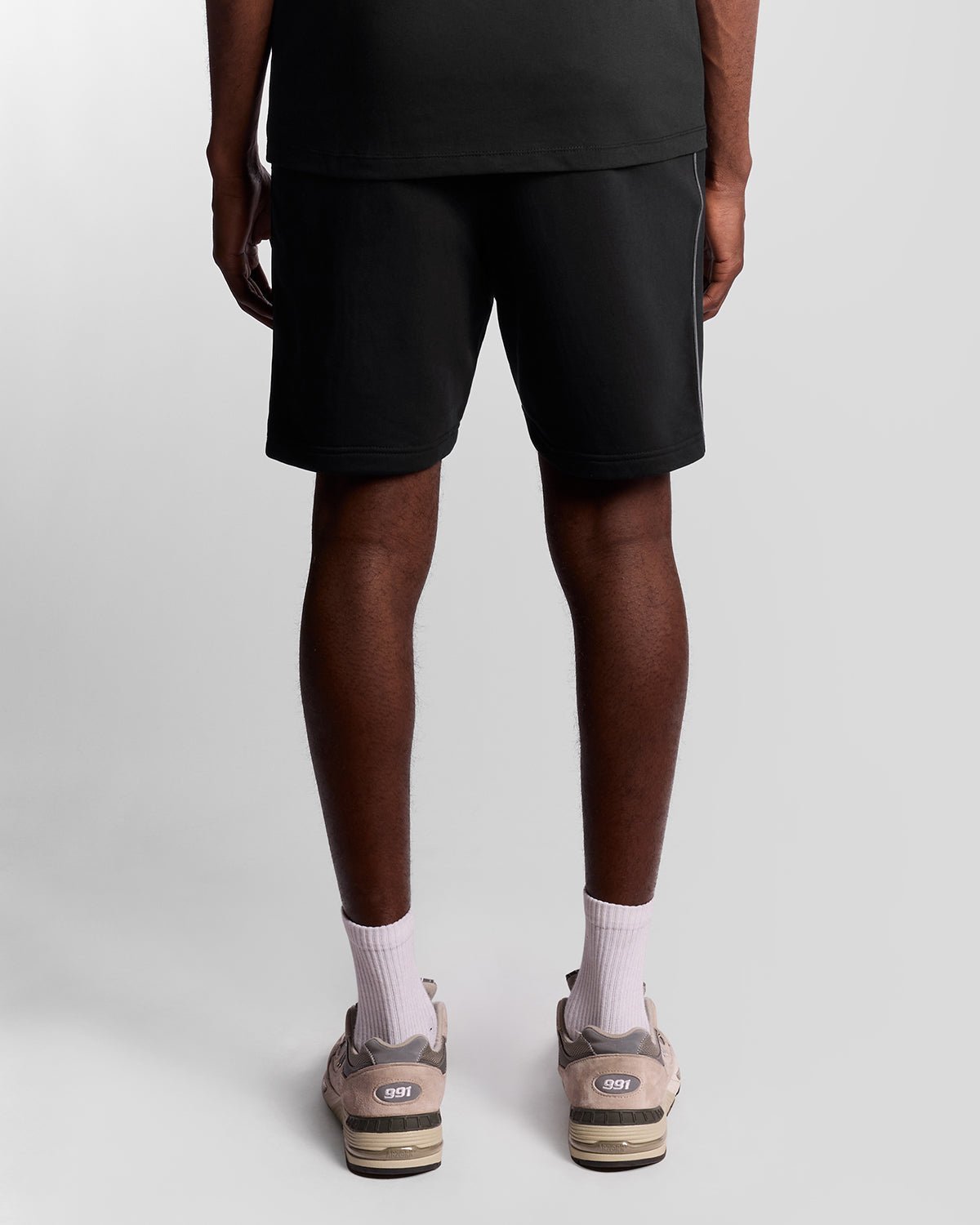 Homme portant un short de sport en bande adhésive, couleur noir de jais