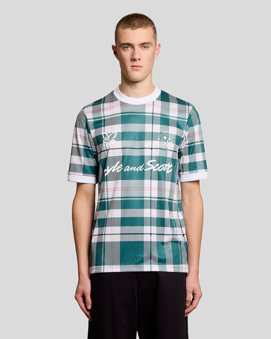 Un homme porte un maillot de football à carreaux tartan de sport, couleur Everglade