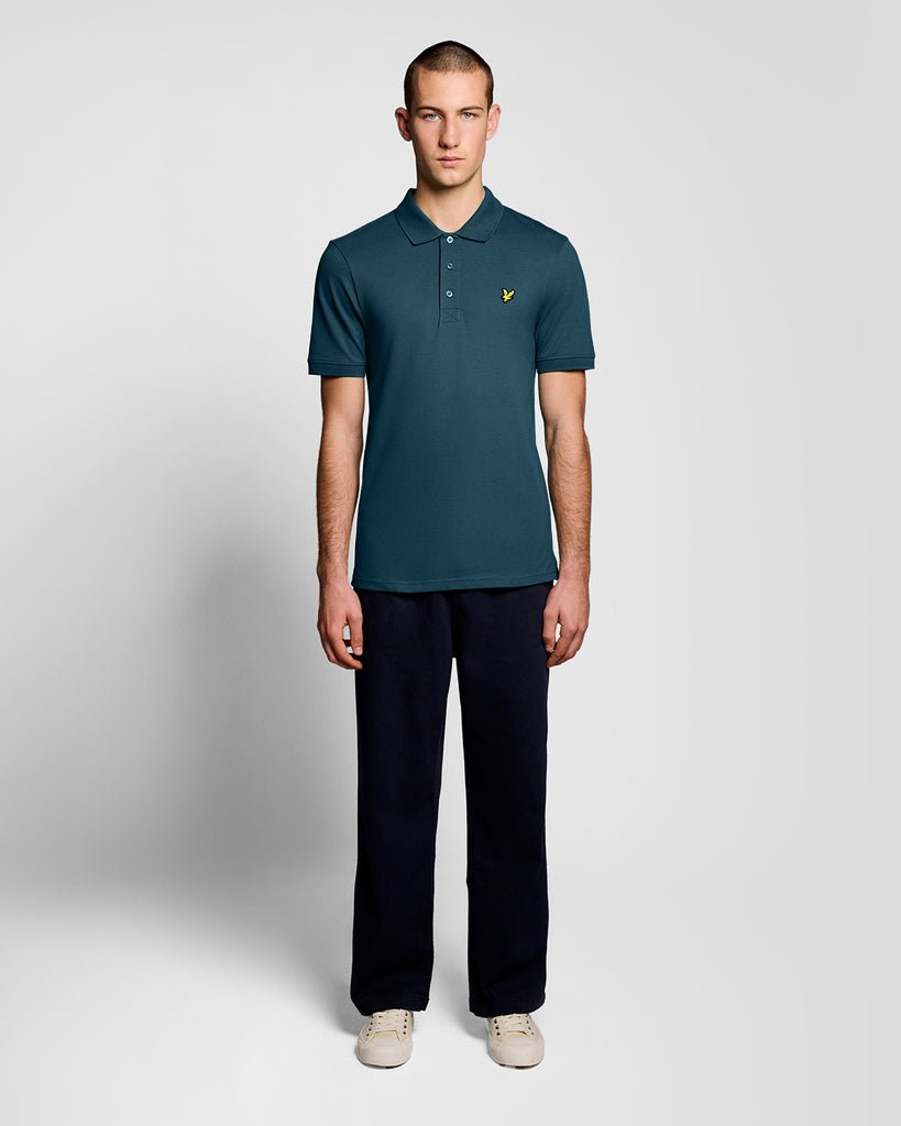 Un homme porte un polo « Everyday Cotton » de couleur bleu sarcelle intense