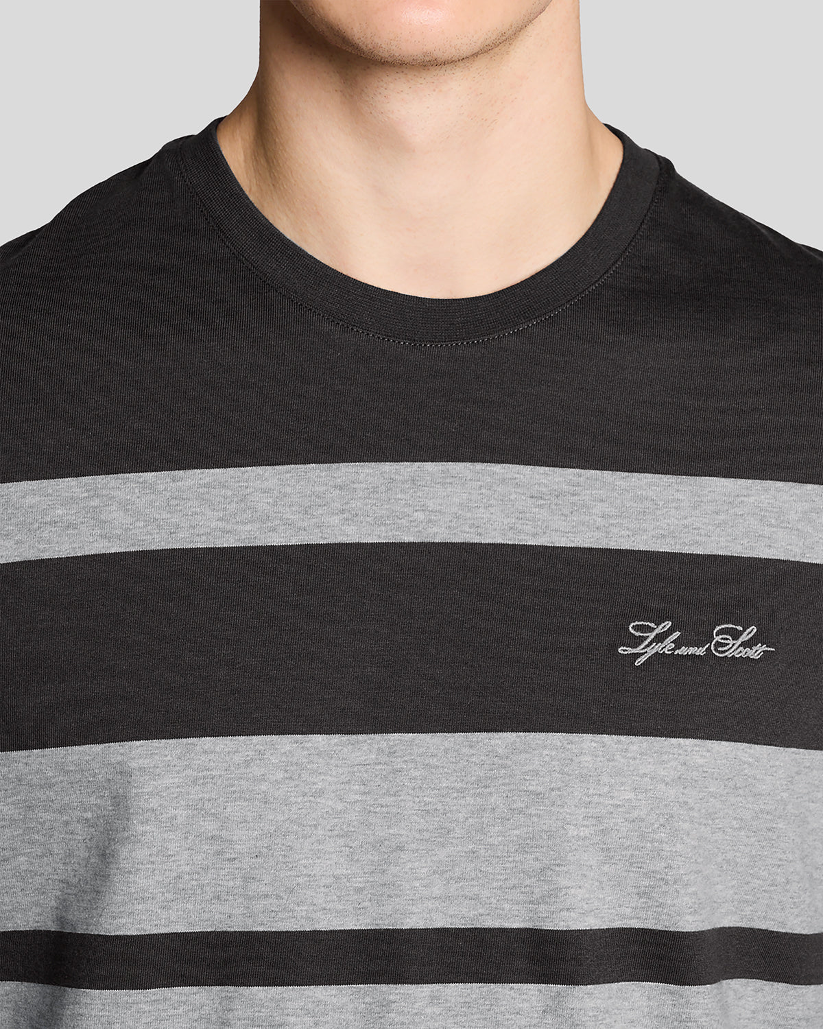 Man wears Relaxed Fit Stripe T-Shirt in Charcoal Grey/ Light Grey Marl