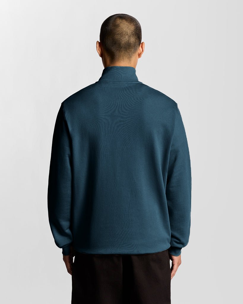 Mann trägt ein „Everyday“ 1/4-Zip-Sweatshirt aus Baumwolle in der Farbe „Rich Teal“