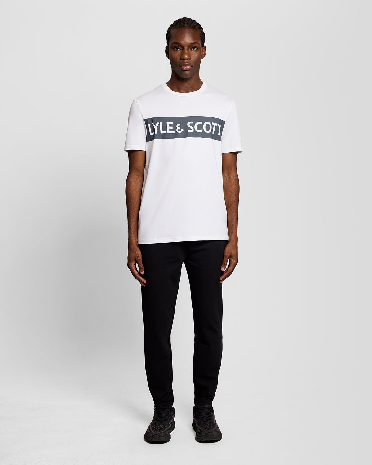Homme portant un t-shirt blanc avec un logo sur la poitrine