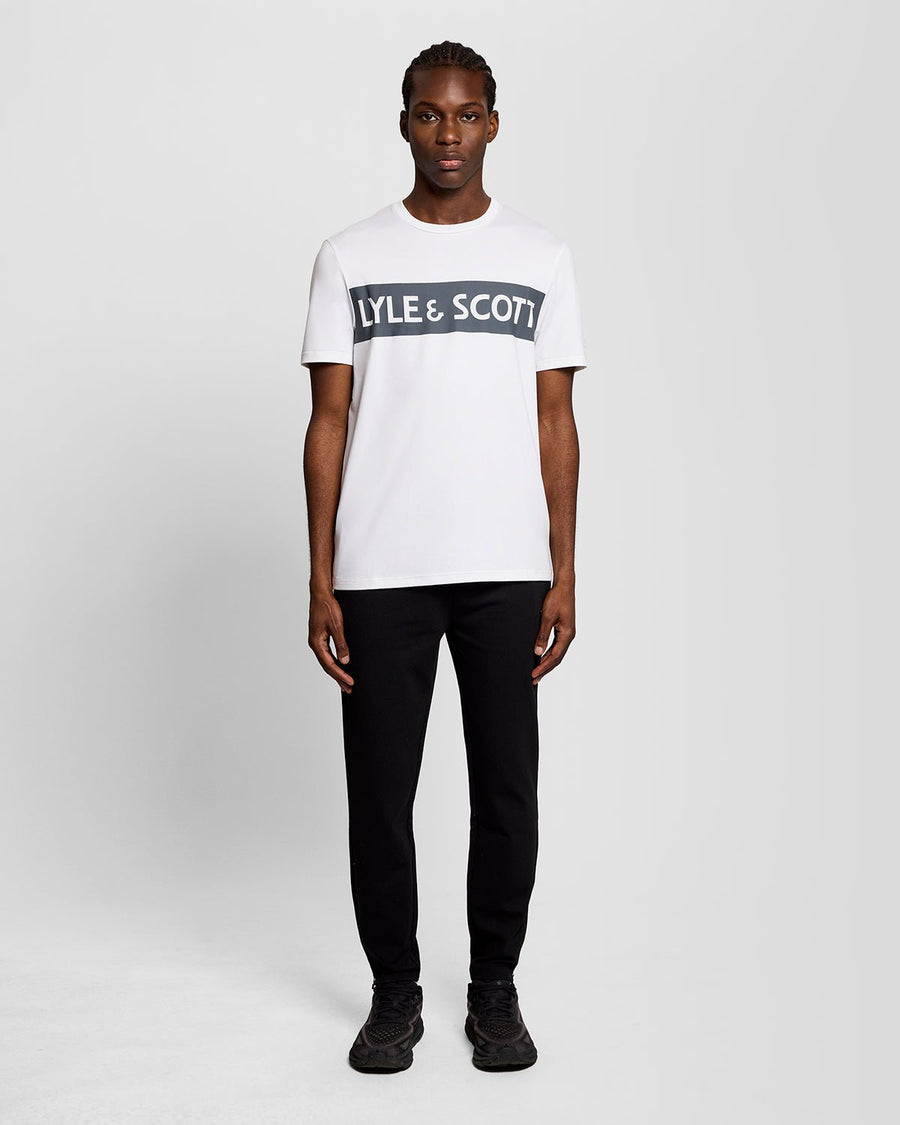 Homme portant un t-shirt blanc avec un logo sur la poitrine