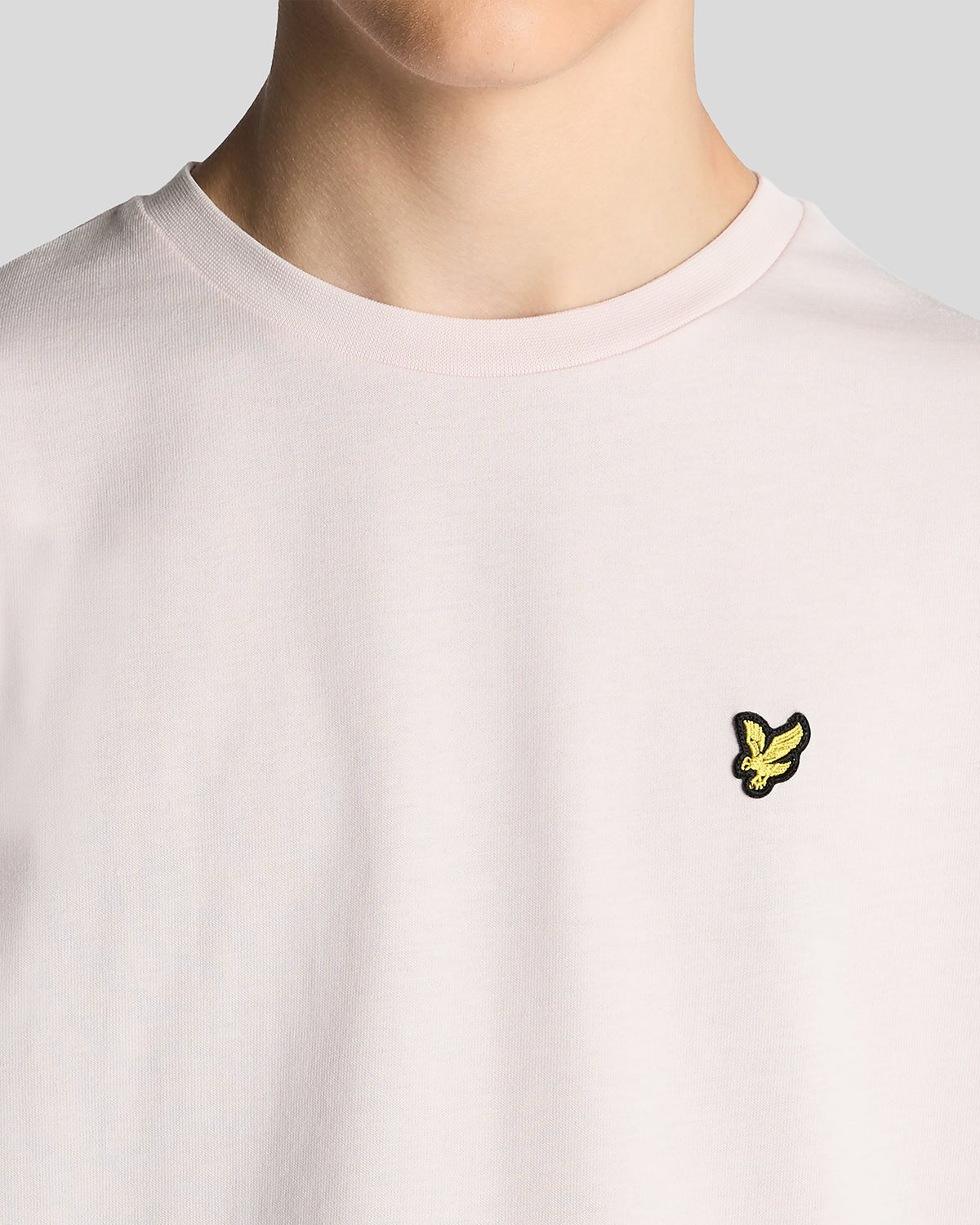 Un homme porte un t-shirt à col rond en coton rose pâle